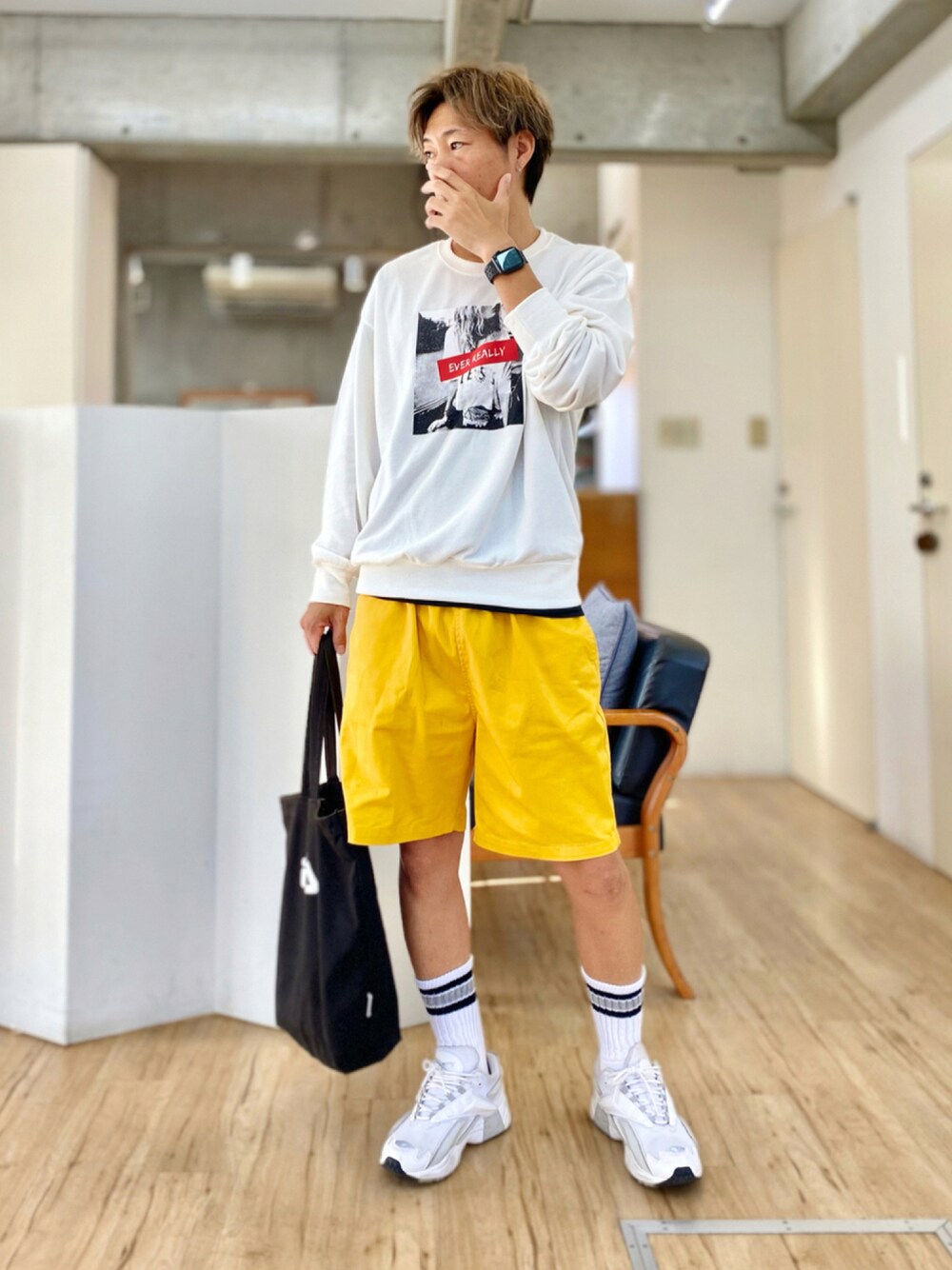 イエロー系のチノパンツ、ホワイト系のスウェット、ホワイト系のスニーカーを着用したメンズの秋コーディネートの1枚目の写真
