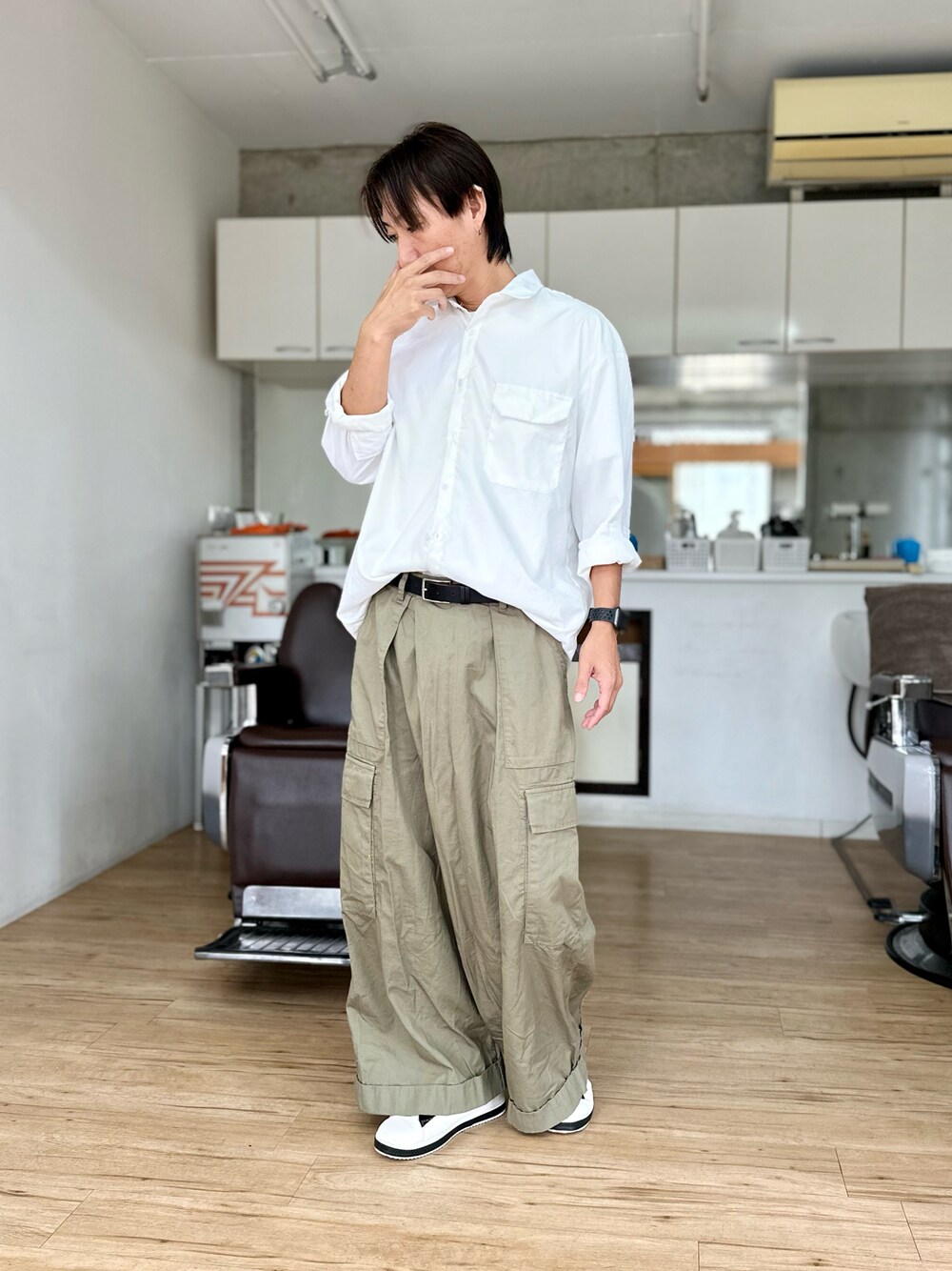 ホワイト系のシャツ/ブラウス、グリーン系のカーゴパンツ、ブラック系のスニーカーを着用したメンズの秋コーディネートの1枚目の写真