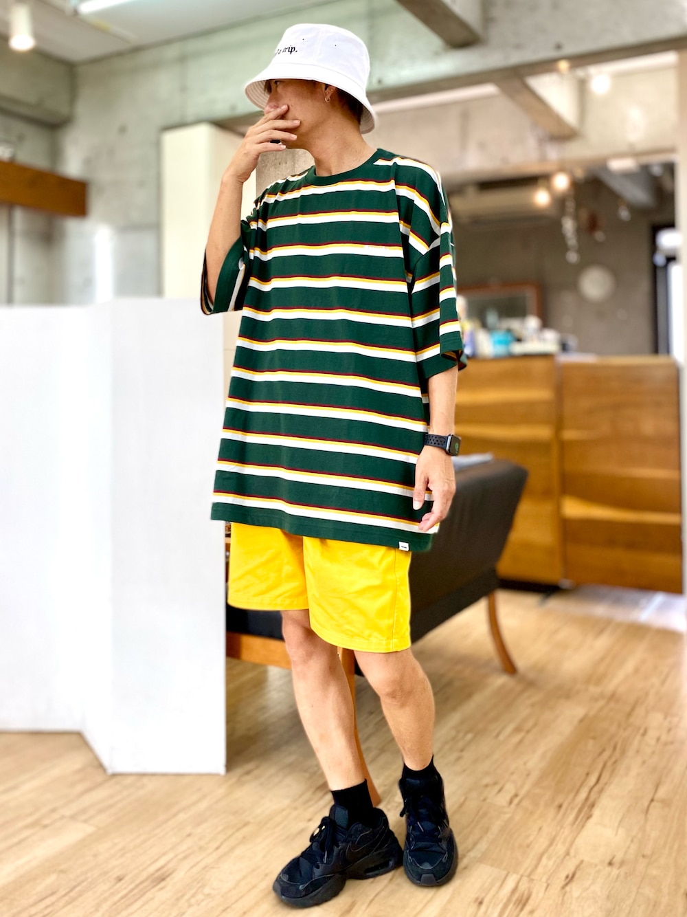グリーン系のTシャツ/カットソー、イエロー系のチノパンツ、ブラック系のスニーカーを着用したメンズの夏コーディネートの1枚目の写真