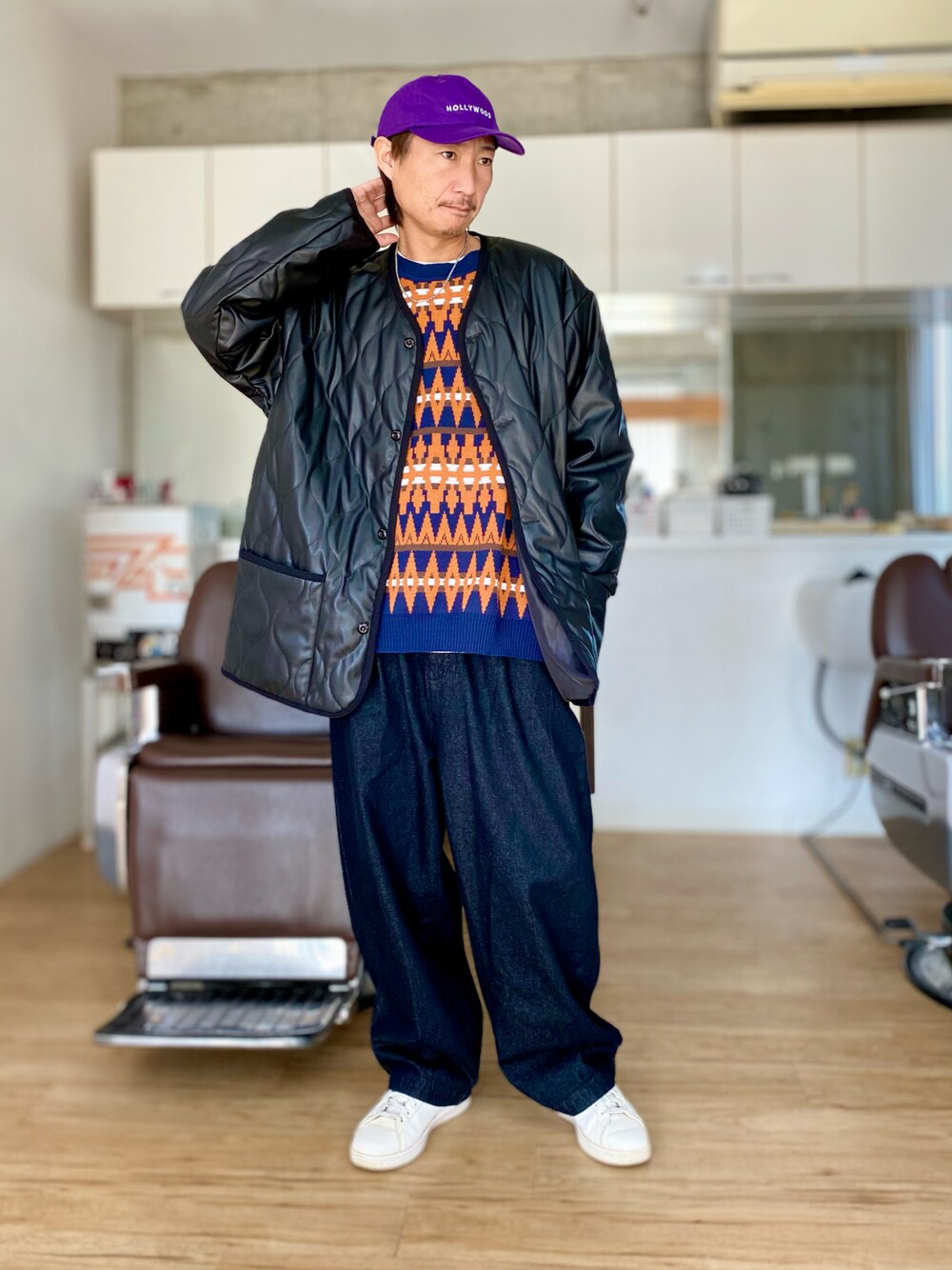 ブラック系のデニムパンツ、ブルー系のベスト、ブラック系のダウンジャケット/コートを着用したメンズの冬コーディネートの1枚目の写真