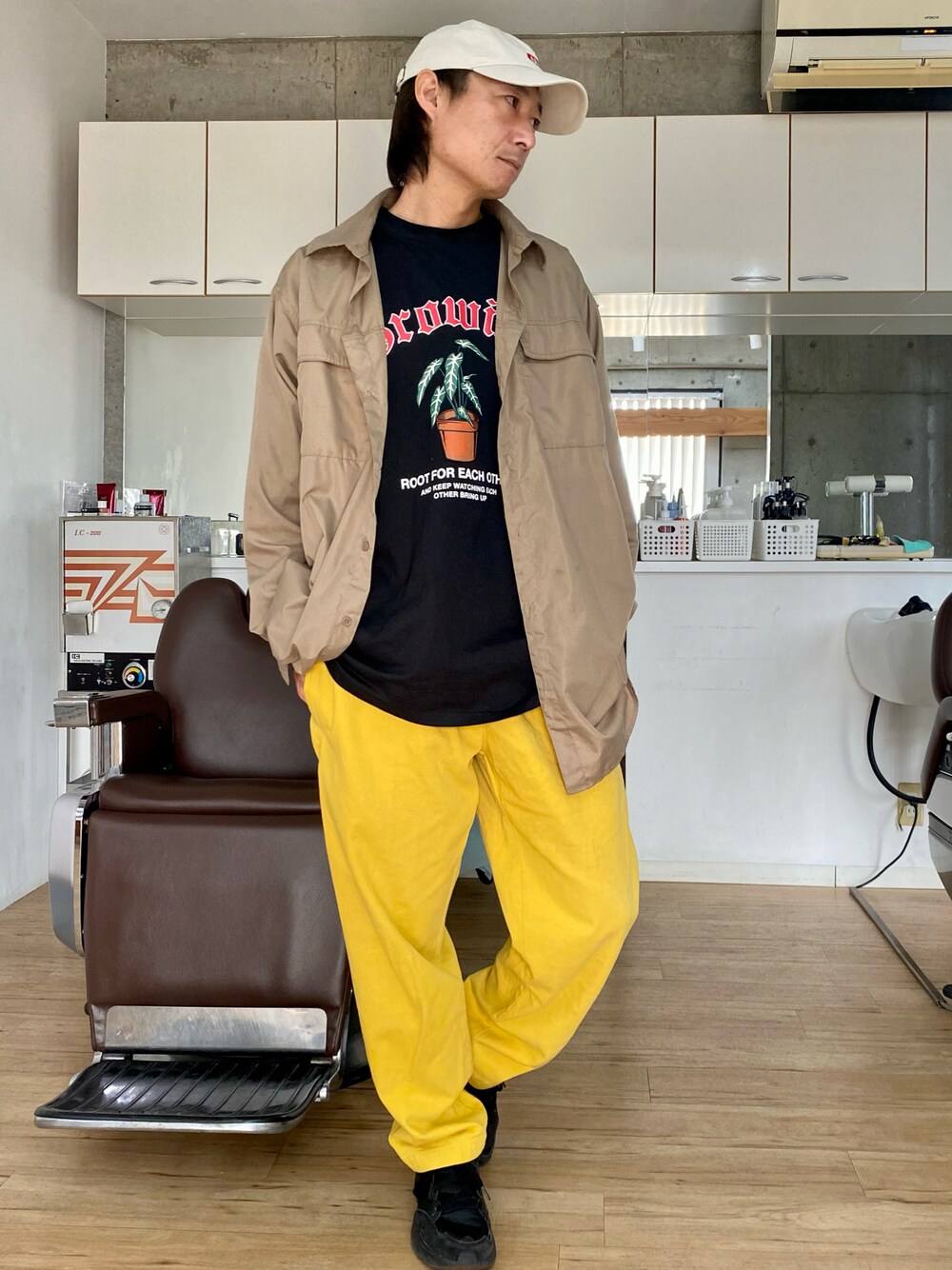 イエロー系のその他パンツ、ブラック系のスニーカー、ブラック系のTシャツ/カットソーを着用したメンズの春コーディネートの1枚目の写真