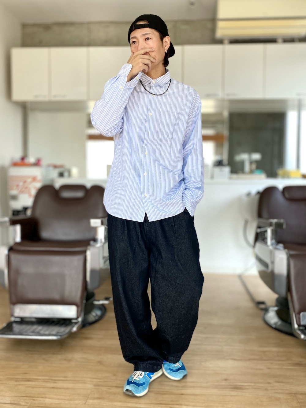 ブラック系のデニムパンツ、ブルー系のスニーカー、ブルー系のシャツ/ブラウスを着用したメンズの春コーディネートの1枚目の写真