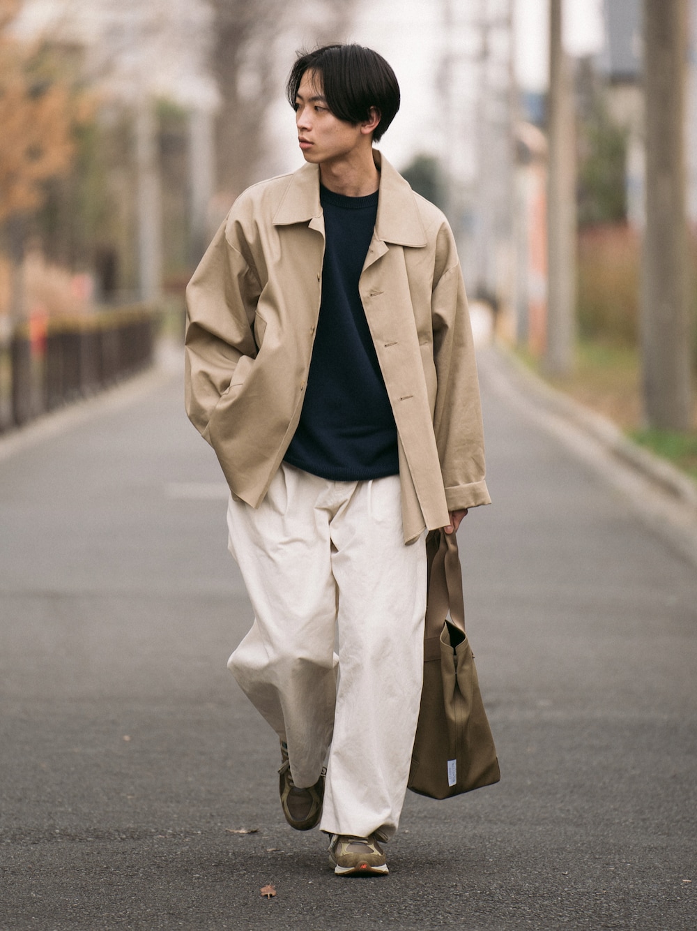 ベージュ系のブルゾン、ブルー系のニット/セーター、ホワイト系のその他パンツを着用したメンズの春コーディネートの1枚目の写真