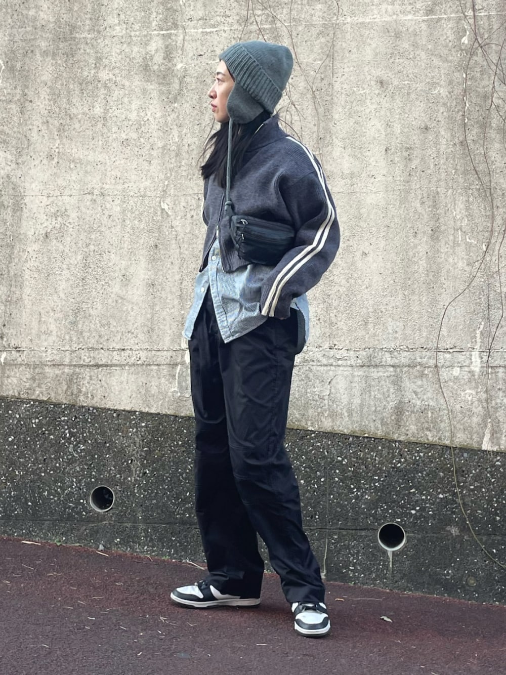 グレー系のニット/セーター、ホワイト系のスニーカー、グレー系のニットキャップ/ビーニーを着用したレディースの冬コーディネートの1枚目の写真