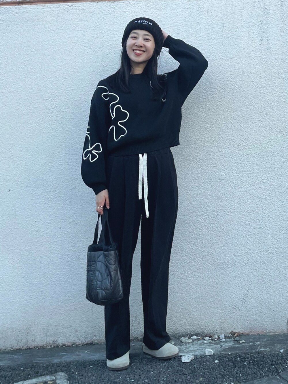 ブラック系のニット/セーター、ブラック系のスウェットパンツ、ベージュ系のサンダルを着用したレディースの冬コーディネートの1枚目の写真