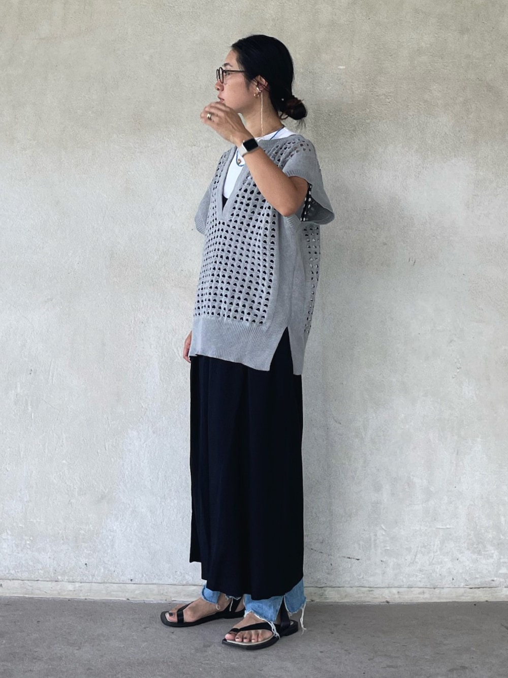グレー系のベスト、ブラック系のワンピース、ブラック系のサンダルを着用したレディースの夏コーディネートの1枚目の写真