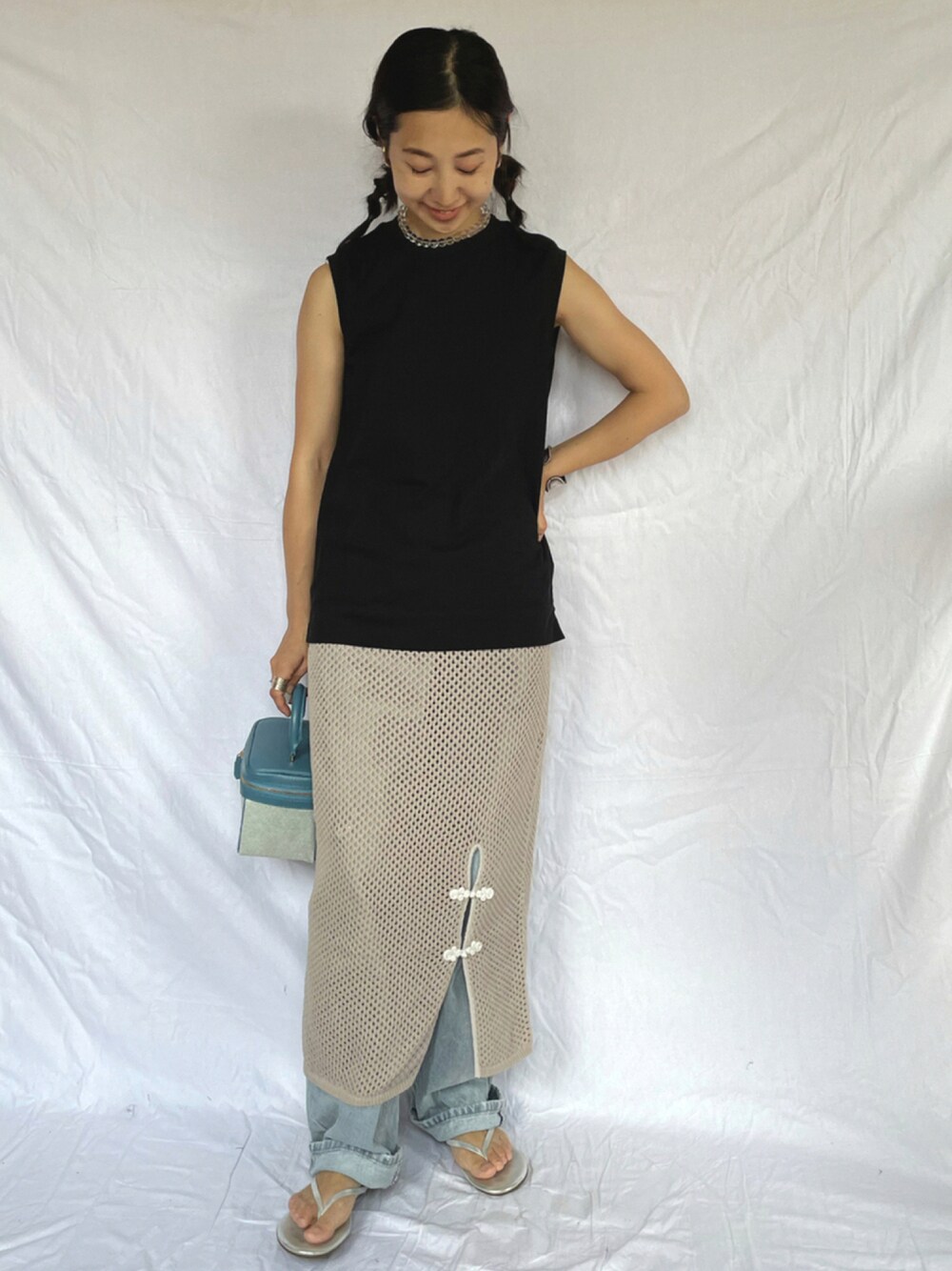 ブラック系のTシャツ/カットソー、グレー系のスカート、ブルー系のハンドバッグを着用したレディースの夏コーディネートの1枚目の写真