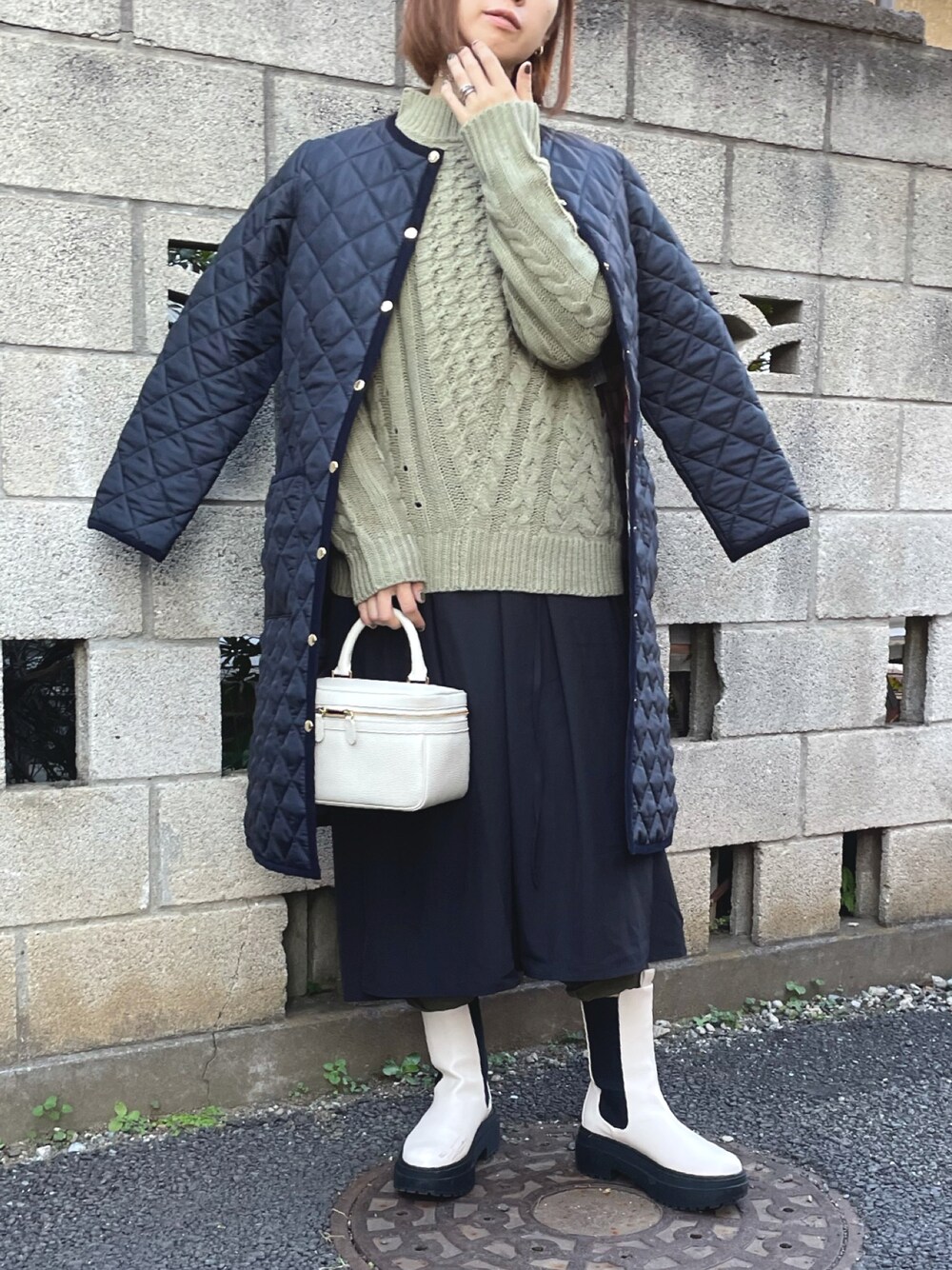 グリーン系のニット/セーター、ブルー系のノーカラーコート、ブラック系のワンピースを着用したレディースの秋コーディネートの1枚目の写真