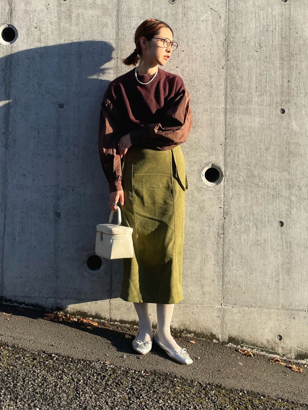 ブラウン系のニット/セーター、グリーン系のスカート、シルバー系のバレエシューズを着用したレディースの冬コーディネートの1枚目の写真