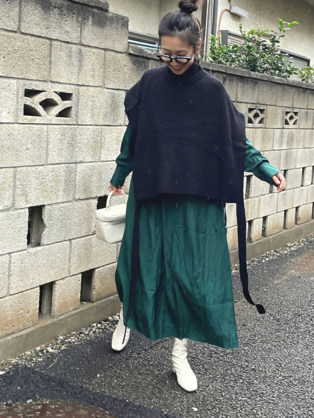 ブラック系のニット/セーター、グリーン系のワンピース、ベージュ系のブーツを着用したレディースの秋コーディネートの1枚目の写真