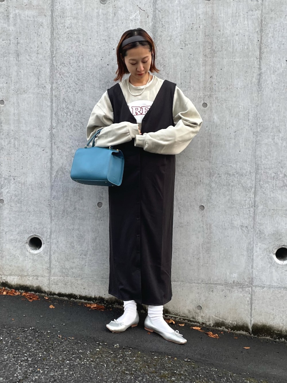 ベージュ系のスウェット、ブラック系のジャンパースカート、シルバー系のバレエシューズを着用したレディースの冬コーディネートの1枚目の写真