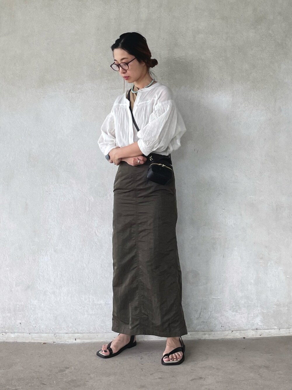 ホワイト系のシャツ/ブラウス、グリーン系のスカート、ブラック系のサンダルを着用したレディースの春コーディネートの1枚目の写真