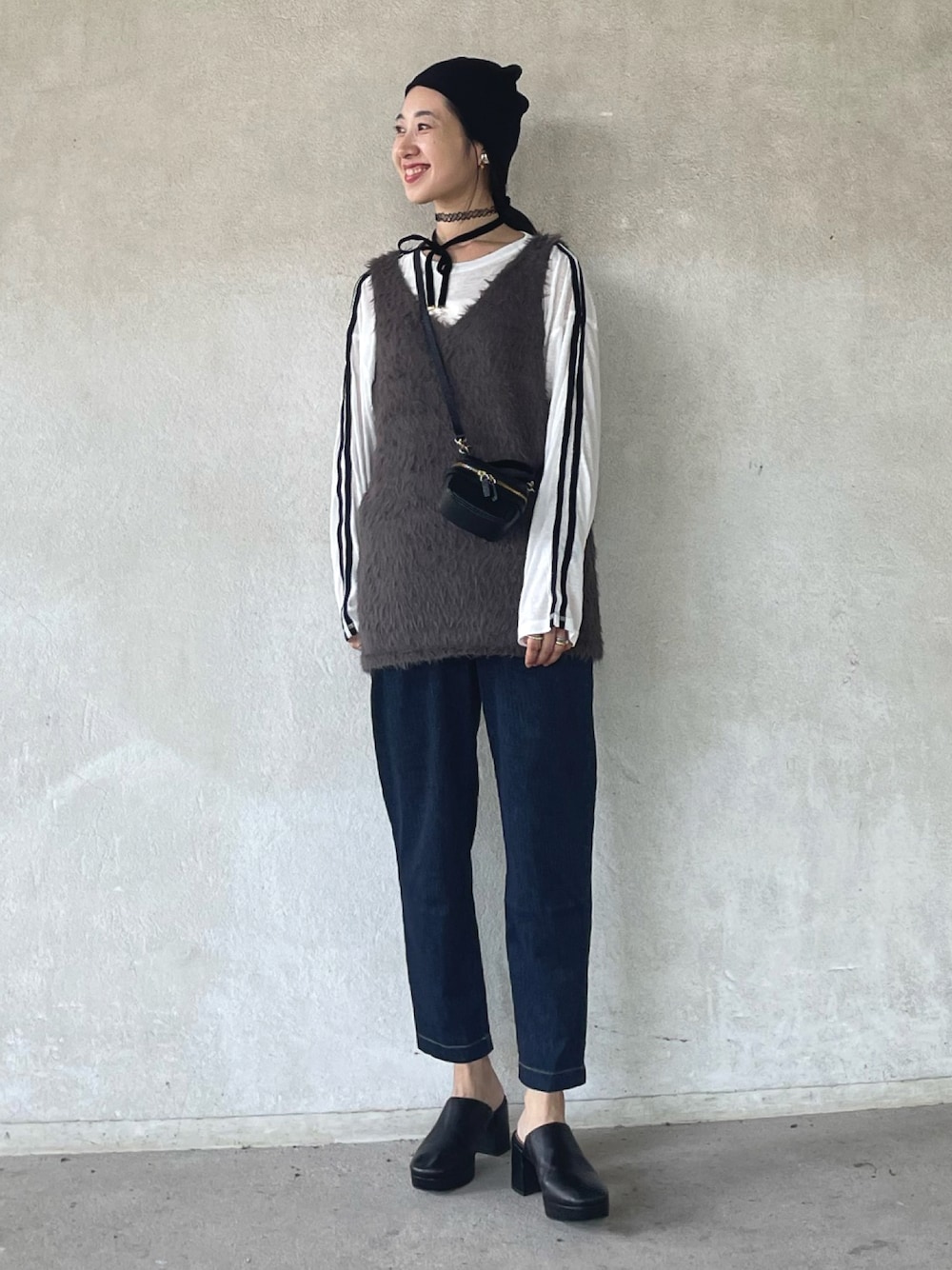 グレー系のベスト、ホワイト系のTシャツ/カットソー、ブルー系のその他パンツを着用したレディースの秋コーディネートの1枚目の写真