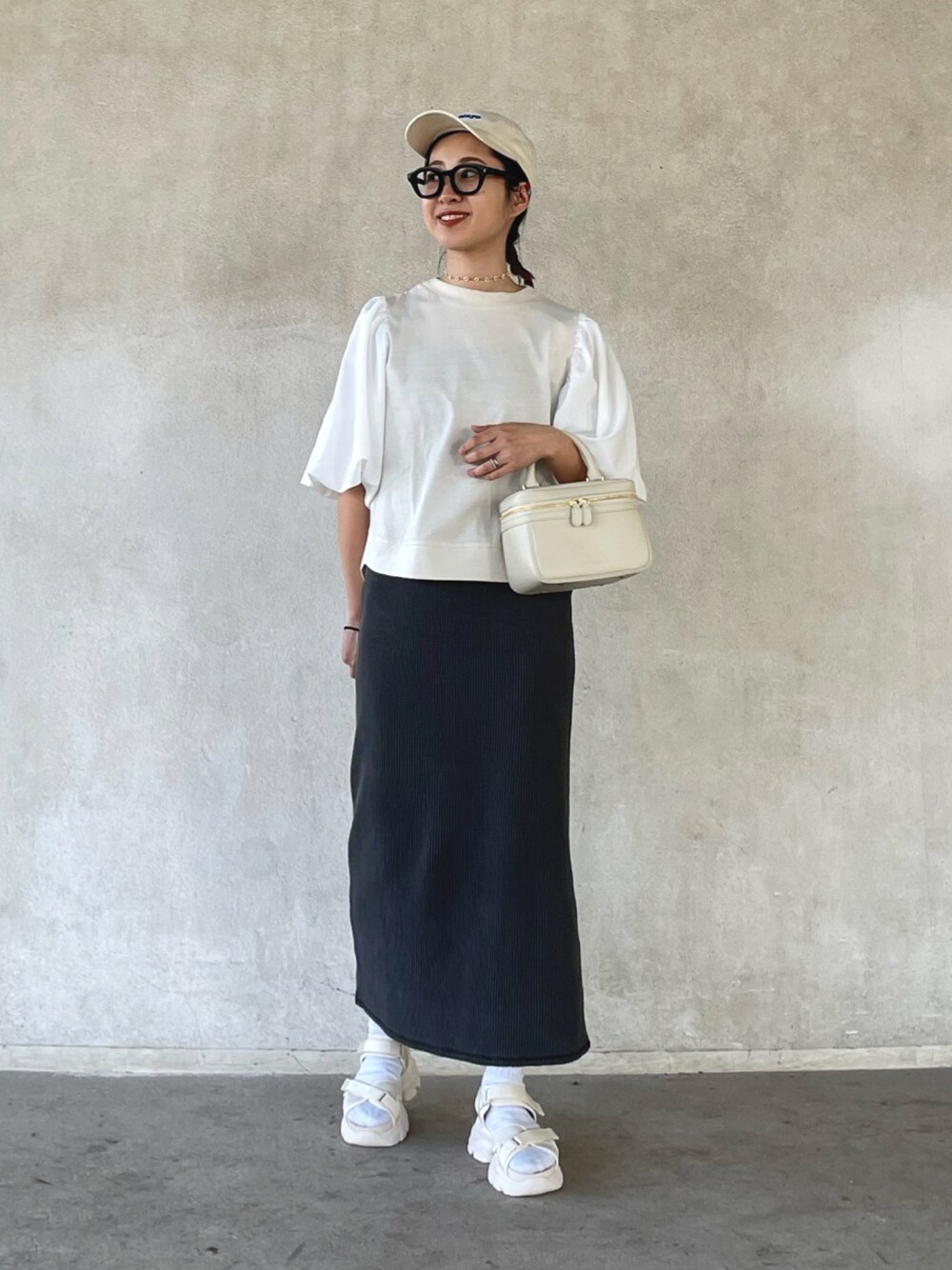 ホワイト系のその他トップス、ブラック系のスカート、ベージュ系のサンダルを着用したレディースの春コーディネートの1枚目の写真