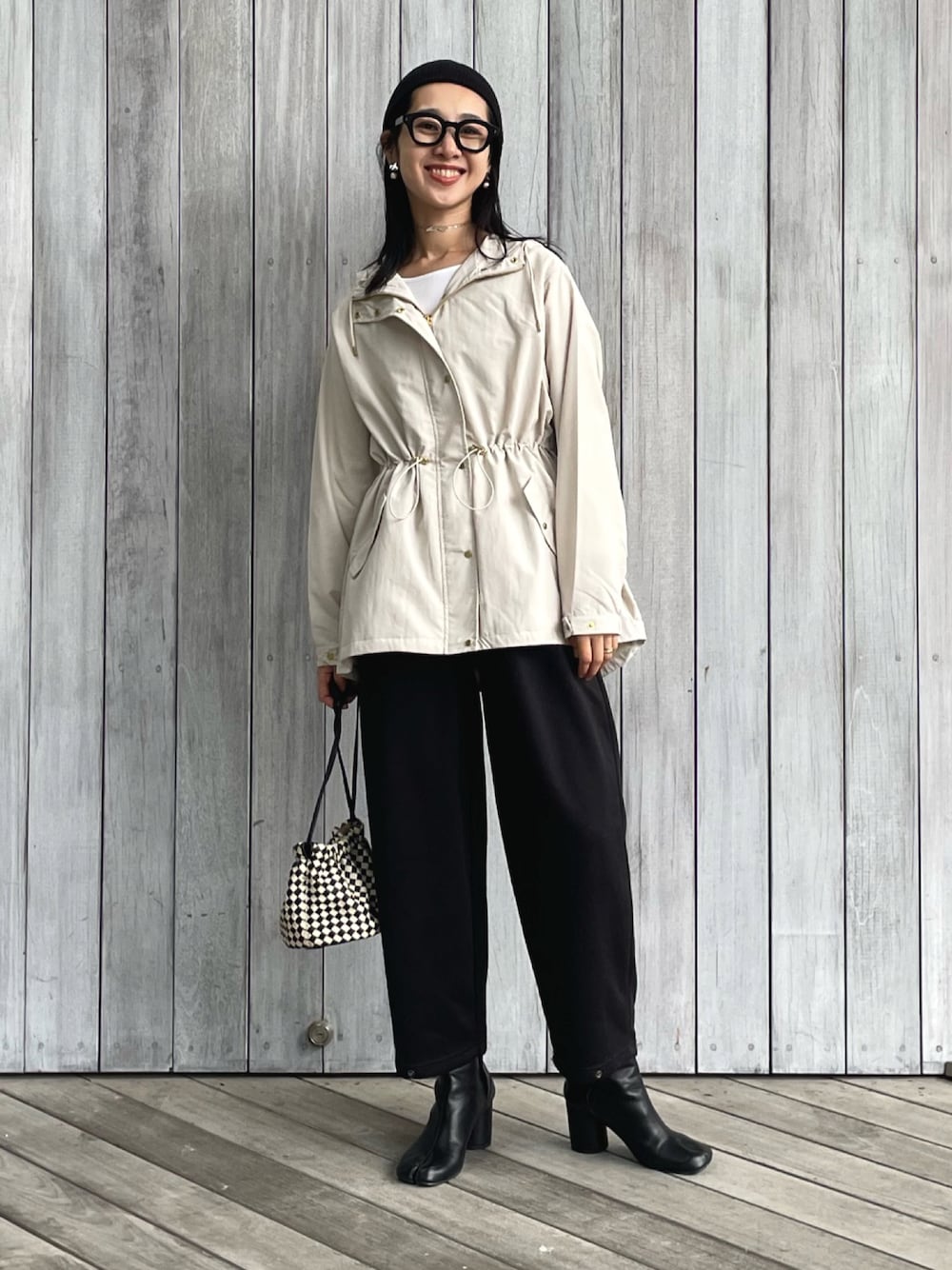 ベージュ系のマウンテンパーカー、ブラック系のスウェットパンツ、ブラック系のショルダーバッグを着用したレディースの秋コーディネートの1枚目の写真