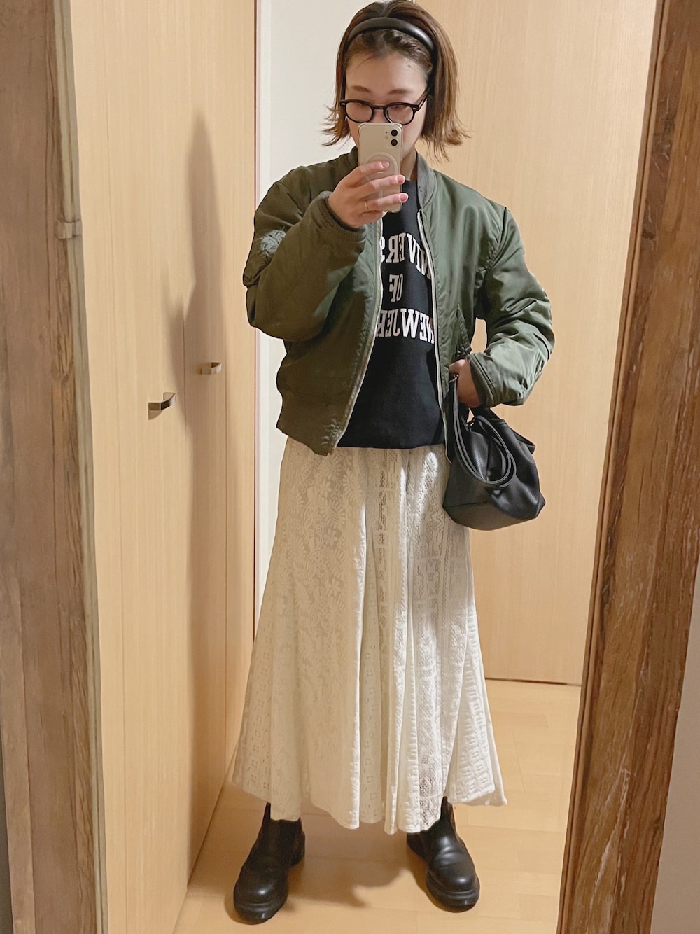 ブラック系のスウェット、グリーン系のMA-1、ブラック系のブーツを着用したレディースの冬コーディネートの1枚目の写真