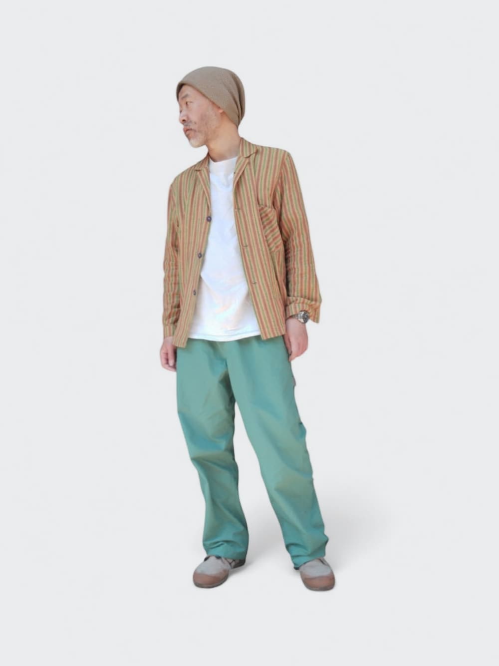 グリーン系のパンツ、ベージュ系のスニーカー、イエロー系のシャツ/ブラウスを着用したメンズの春コーディネートの1枚目の写真