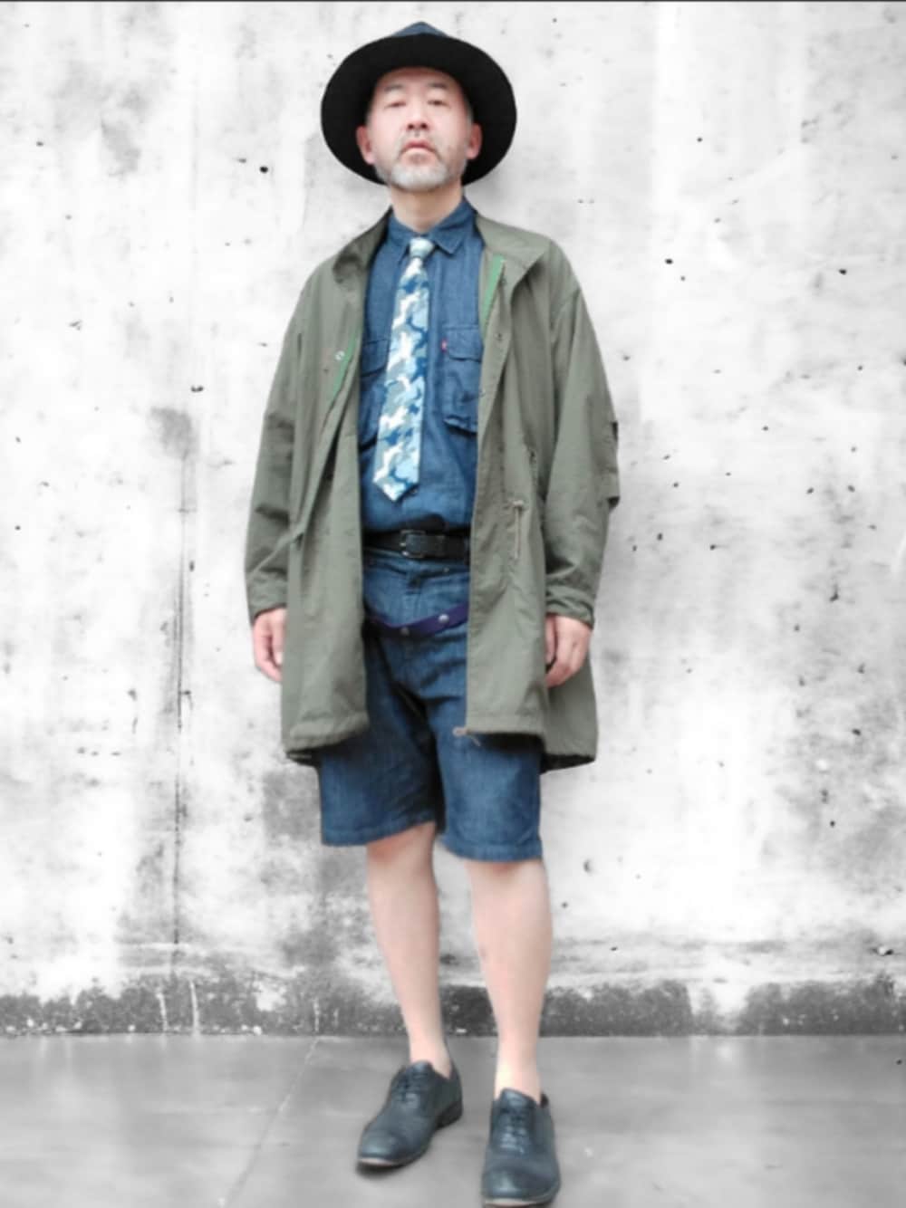 グリーン系のモッズコート、ブルー系のデニムパンツ、ブルー系のハットを着用したメンズの春コーディネートの1枚目の写真