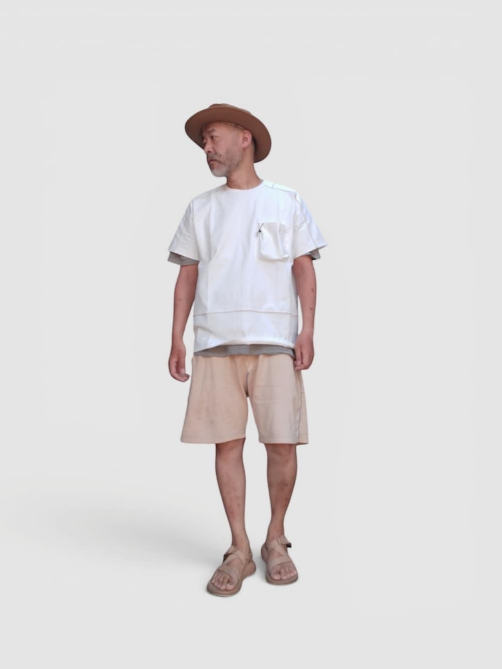 イエロー系のパンツ、ベージュ系のサンダル、ホワイト系のTシャツ/カットソーを着用したメンズの夏コーディネートの1枚目の写真