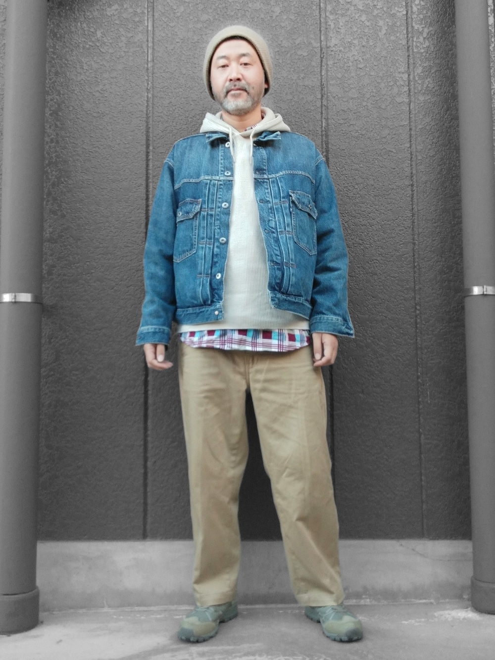ベージュ系のチノパンツ、ベージュ系のパーカー、ブルー系のデニムジャケットを着用したメンズの冬コーディネートの1枚目の写真