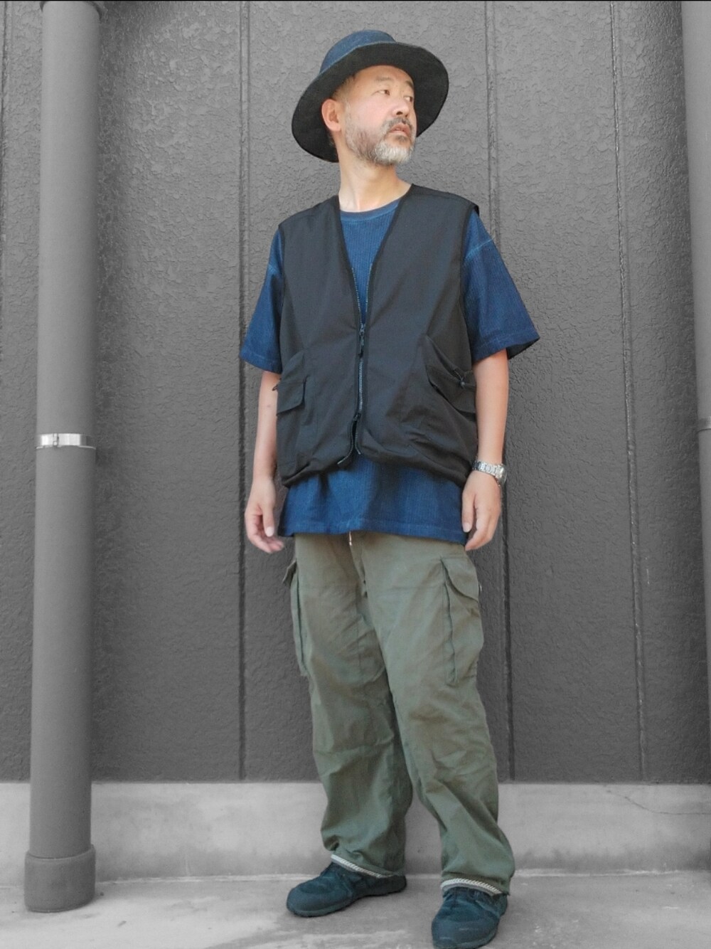 グリーン系のカーゴパンツ、ブラック系のスニーカー、ブルー系のTシャツ/カットソーを着用したメンズの夏コーディネートの1枚目の写真
