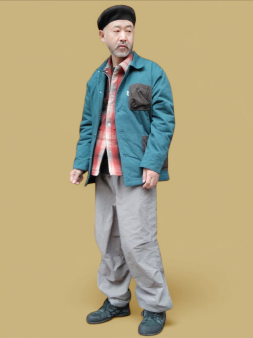 グレー系のパンツ、ブラック系のスニーカー、オレンジ系のシャツ/ブラウスを着用したメンズの冬コーディネートの1枚目の写真