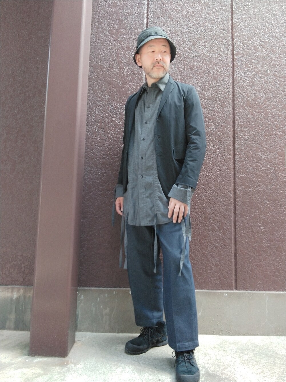 ブラック系のスニーカー、ブルー系のその他パンツ、グレー系のシャツ/ブラウスを着用したメンズの春コーディネートの1枚目の写真