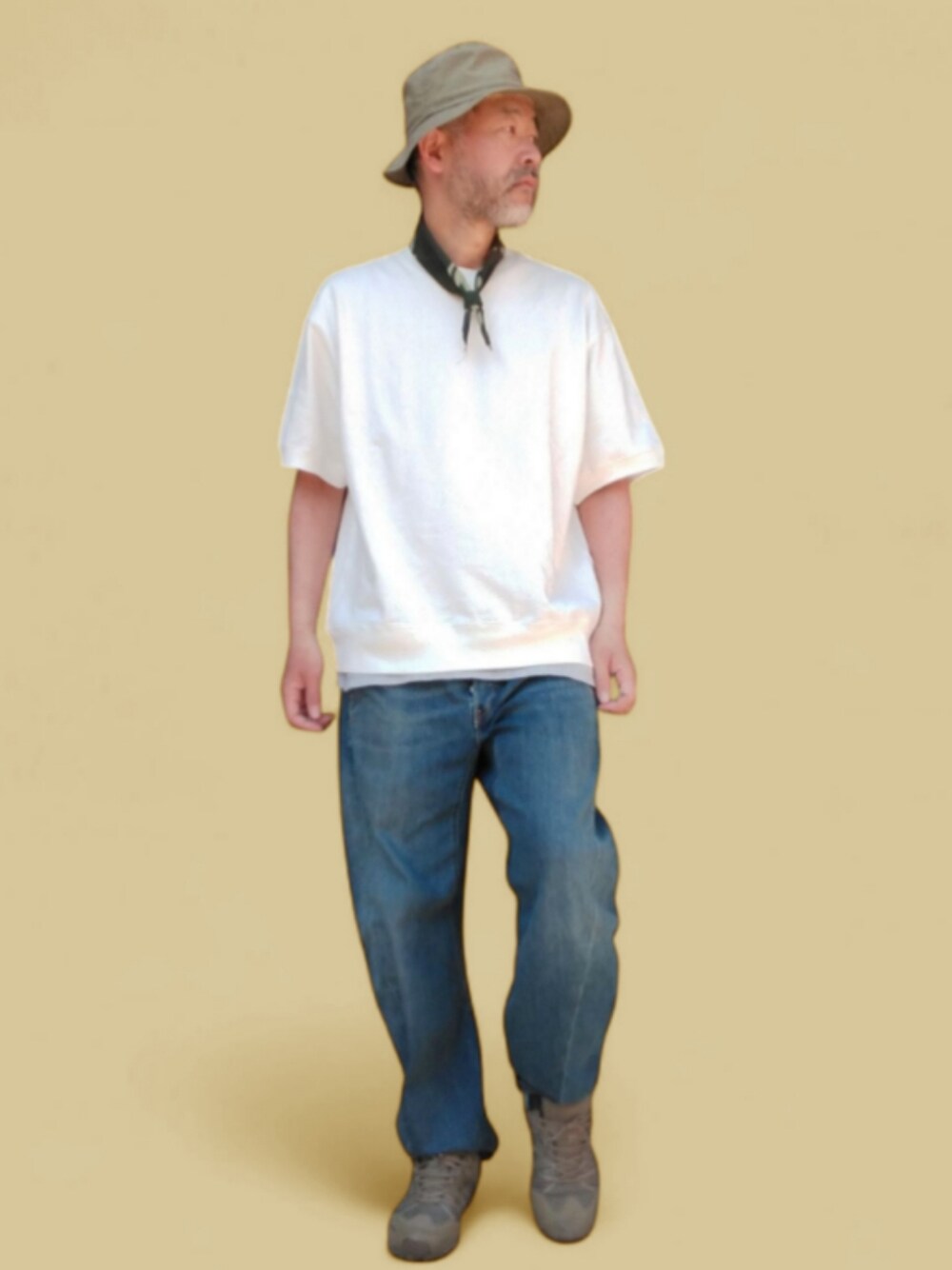 ブルー系のデニムパンツ、ホワイト系のTシャツ/カットソー、グリーン系のハットを着用したメンズの春コーディネートの1枚目の写真