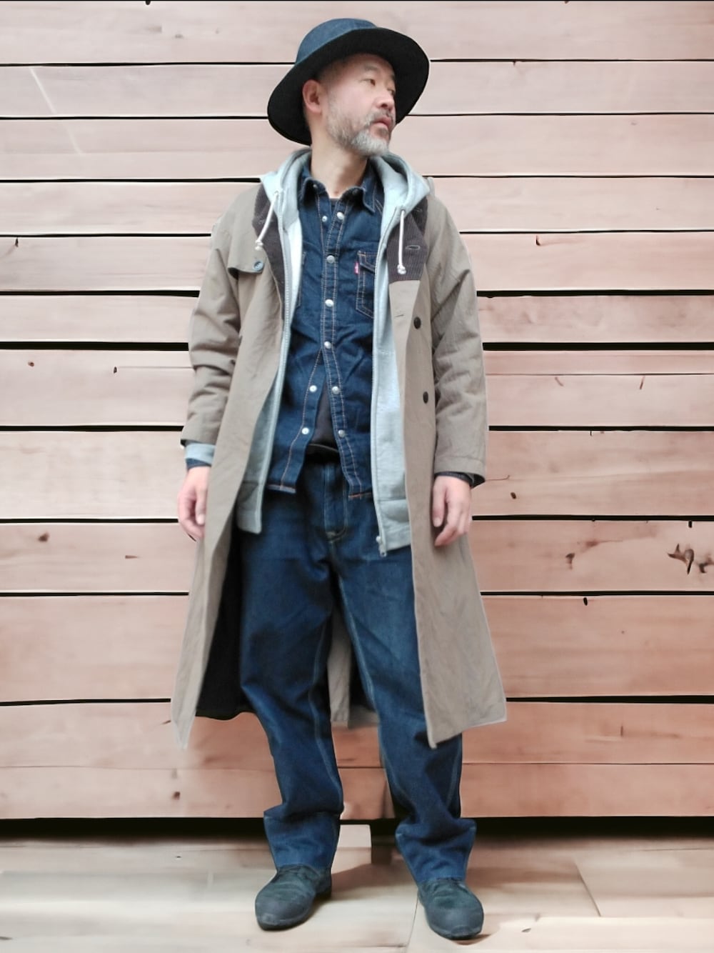 グリーン系のトレンチコート、ブルー系のシャツ/ブラウス、ブルー系のデニムパンツを着用したメンズの冬コーディネートの1枚目の写真