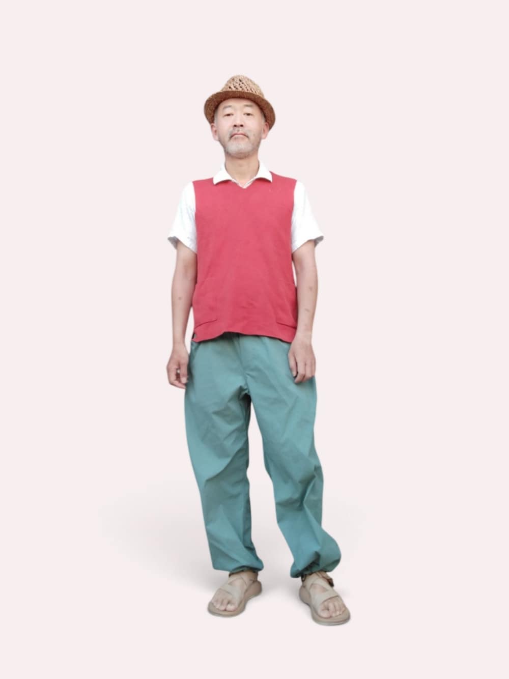 グリーン系のパンツ、ベージュ系のサンダル、レッド系のベストを着用したメンズの夏コーディネートの1枚目の写真