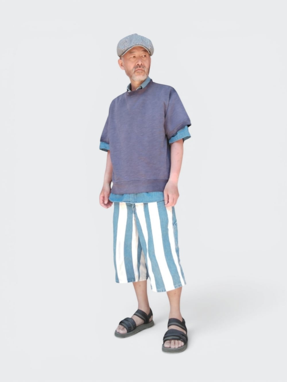 グリーン系のサンダル、ブルー系のパンツ、パープル系のTシャツ/カットソーを着用したメンズの春コーディネートの1枚目の写真