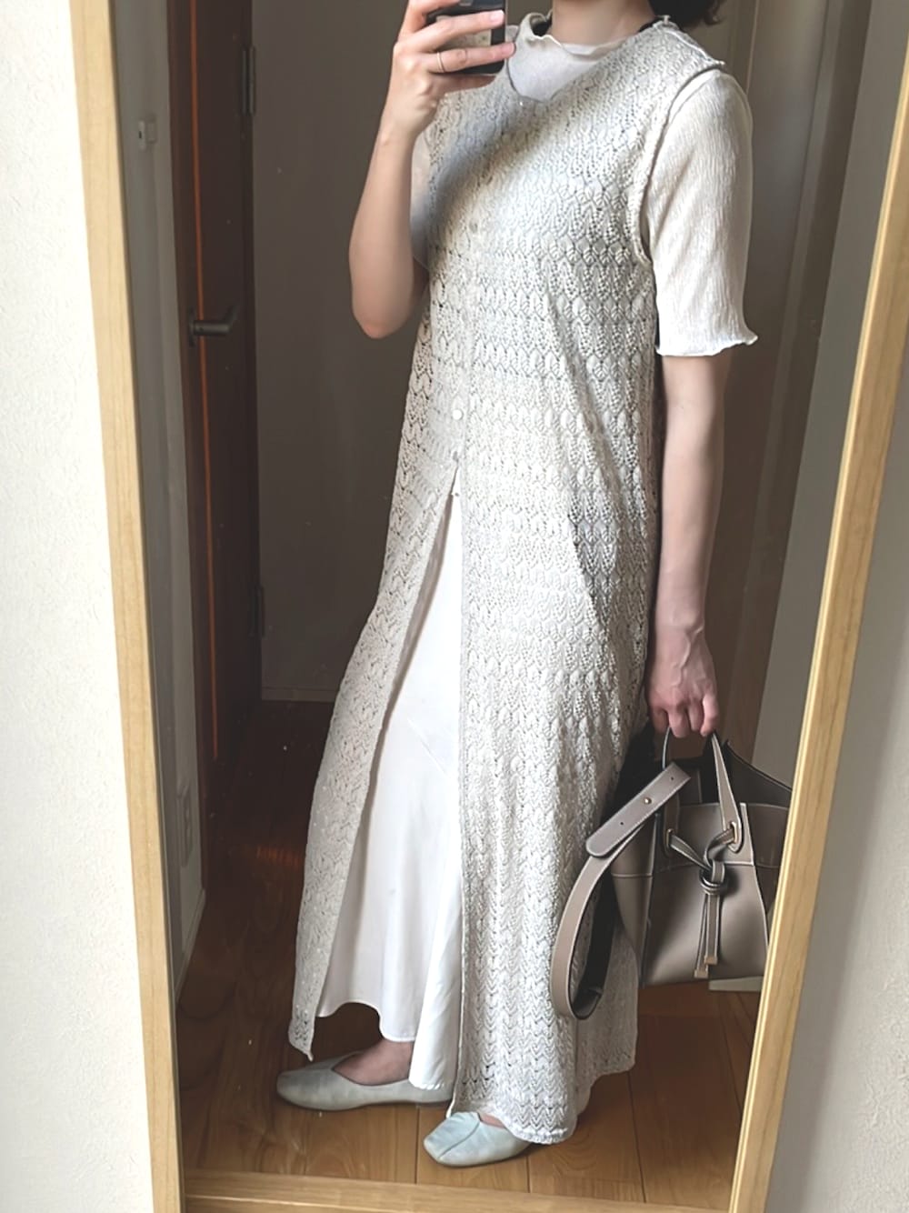 ベージュ系のショルダーバッグ、ホワイト系のシューズ、ホワイト系のスカートを着用したレディースの春コーディネートの1枚目の写真