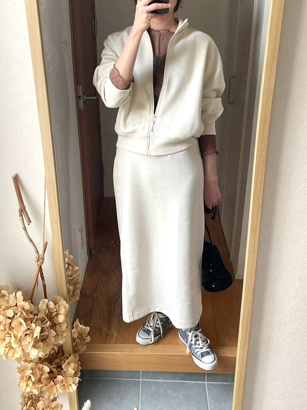 ブラック系のバッグ、ホワイト系のジャケット/アウター、ホワイト系のスカートを着用したレディースの春コーディネートの1枚目の写真