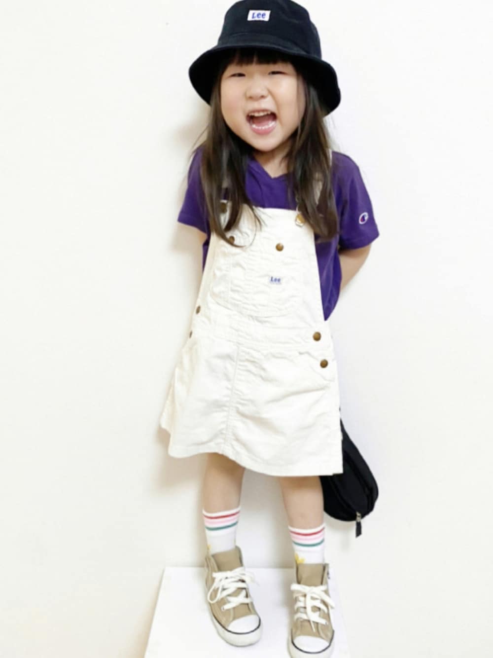 パープル系のTシャツ/カットソー、ベージュ系のスニーカー、ブラック系のボディバッグ/ウエストポーチを着用したキッズの夏コーディネートの1枚目の写真