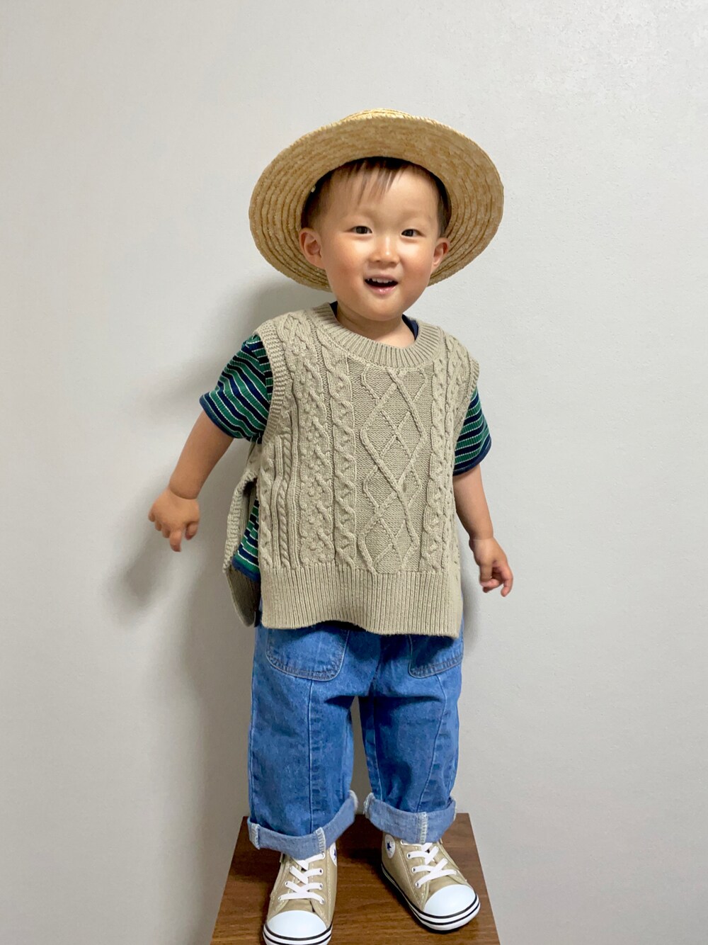 グリーン系のベスト、グリーン系のTシャツ/カットソー、ブルー系のデニムパンツを着用したキッズの春コーディネートの1枚目の写真