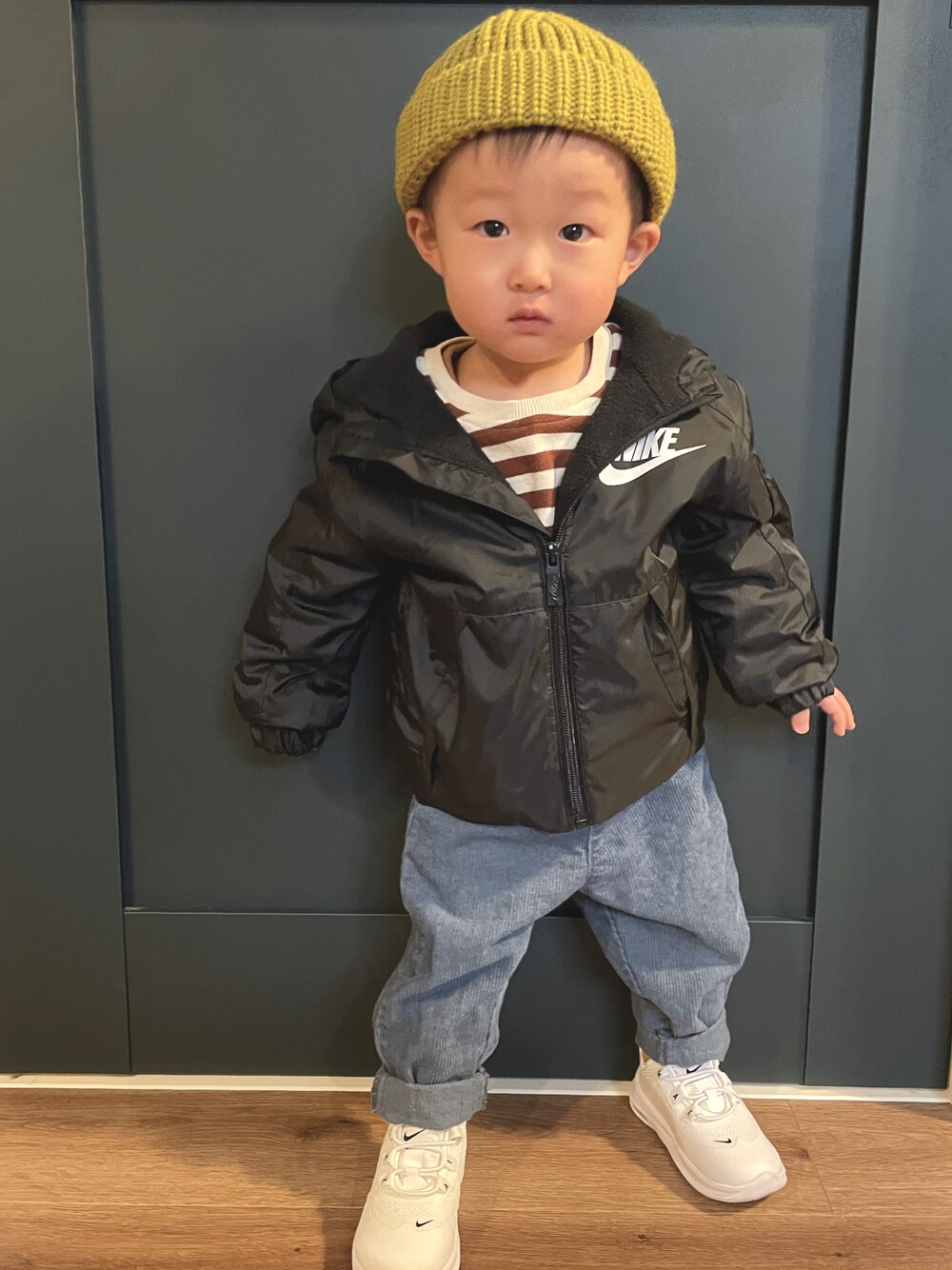 ブラック系のナイロンジャケット、ブルー系のその他パンツ、イエロー系のニットキャップ/ビーニーを着用したキッズの冬コーディネートの1枚目の写真