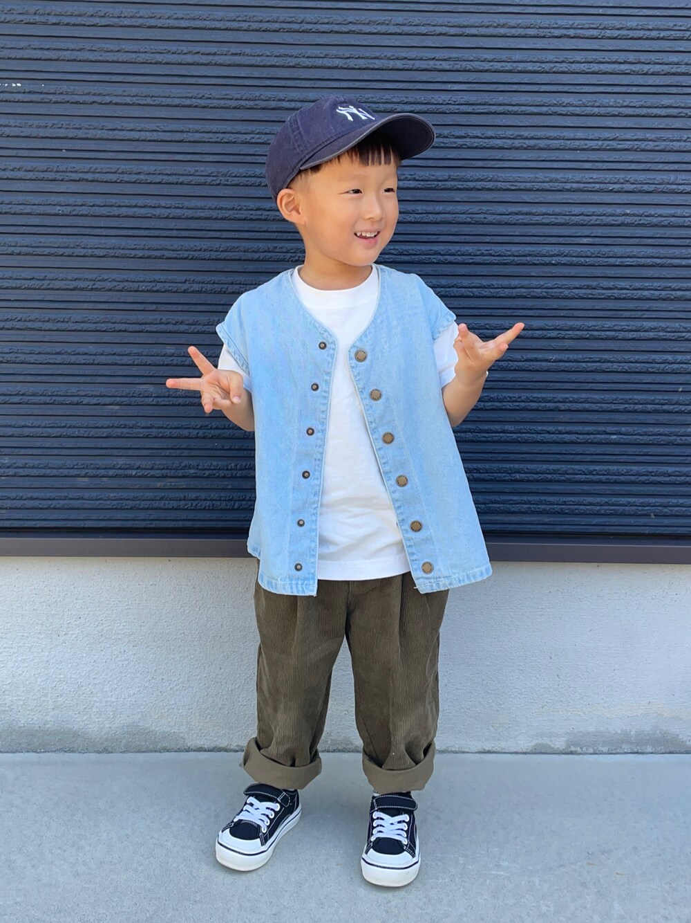 ブルー系のベスト、ブラウン系のその他パンツ、ブラック系のスニーカーを着用したキッズの秋コーディネートの1枚目の写真