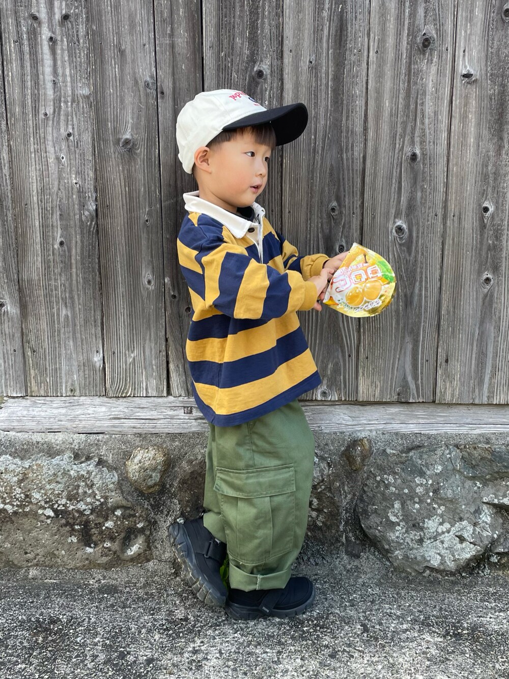 イエロー系のTシャツ/カットソー、グリーン系のカーゴパンツ、ブラック系のスニーカーを着用したキッズの秋コーディネートの1枚目の写真
