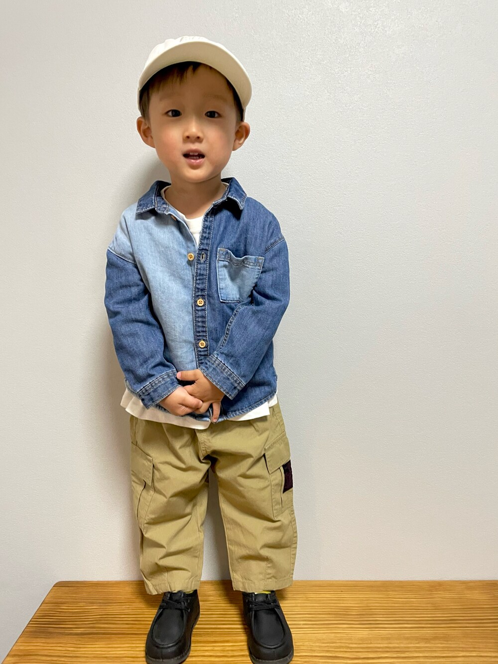 ホワイト系のTシャツ/カットソー、ベージュ系のカーゴパンツ、ブラック系のブーツを着用したキッズの春コーディネートの1枚目の写真