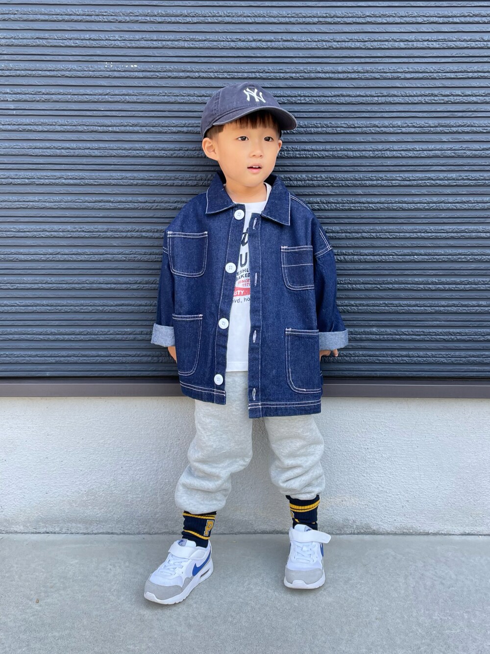 ホワイト系のTシャツ/カットソー、ブルー系のデニムジャケット、グレー系のスウェットパンツを着用したキッズの秋コーディネートの1枚目の写真