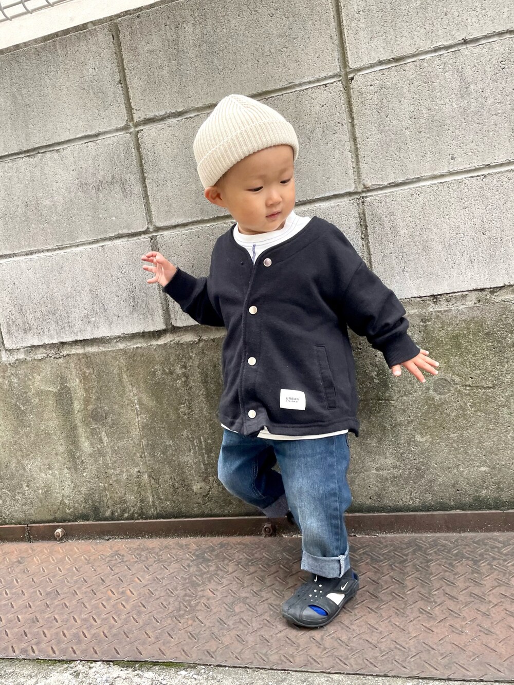 ブラック系のノーカラージャケット、ホワイト系のTシャツ/カットソー、ブルー系のデニムパンツを着用したキッズの春コーディネートの1枚目の写真