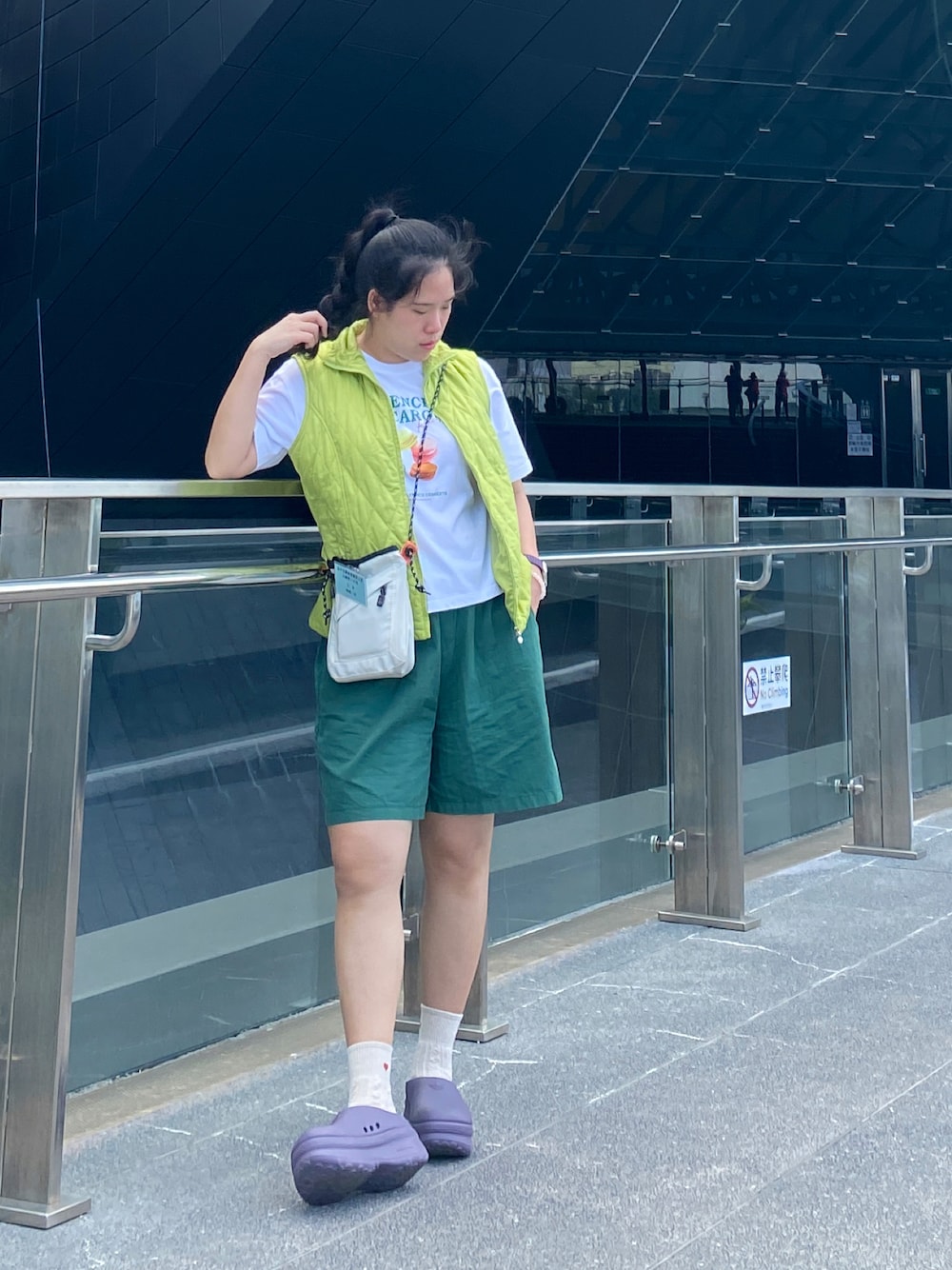 グリーン系のカーゴパンツ、パープル系のスリッポン、ホワイト系のバッグを着用したレディースの秋コーディネートの1枚目の写真