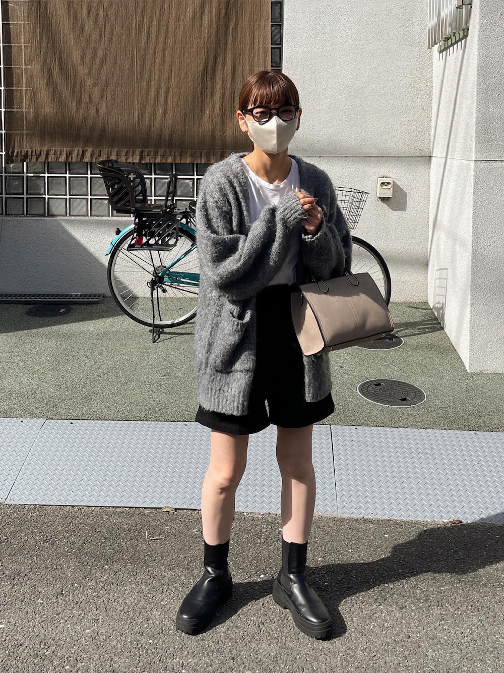 ブラック系のその他パンツ、グレー系のカーディガン/ボレロ、ベージュ系のショルダーバッグを着用したレディースの秋コーディネートの1枚目の写真