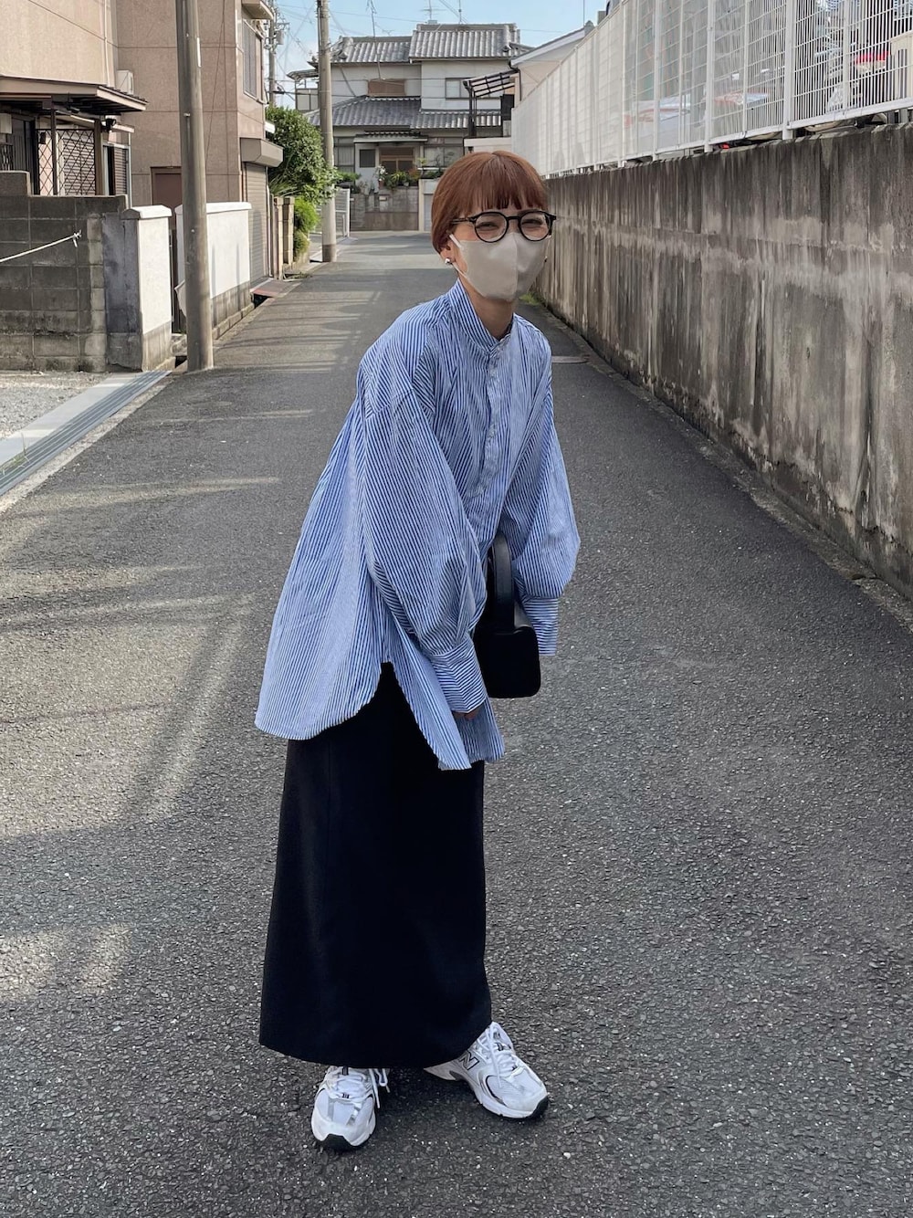 ブルー系のシャツ/ブラウス、ブラック系のスカートを着用したレディースの秋コーディネートの1枚目の写真