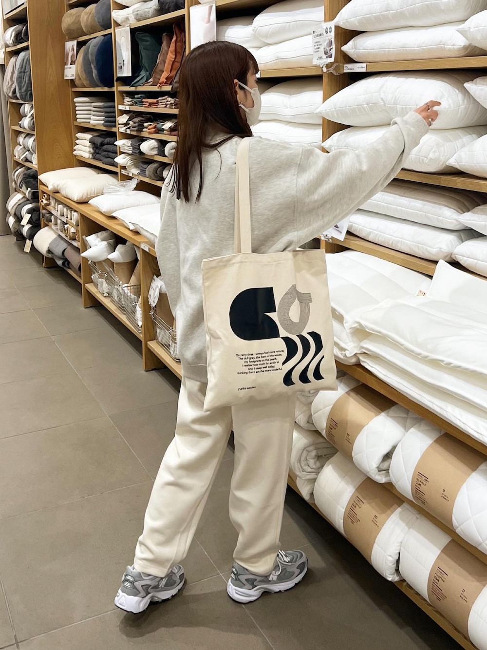 ベージュ系のスウェット、ホワイト系のパンツを着用したレディースの秋コーディネートの1枚目の写真