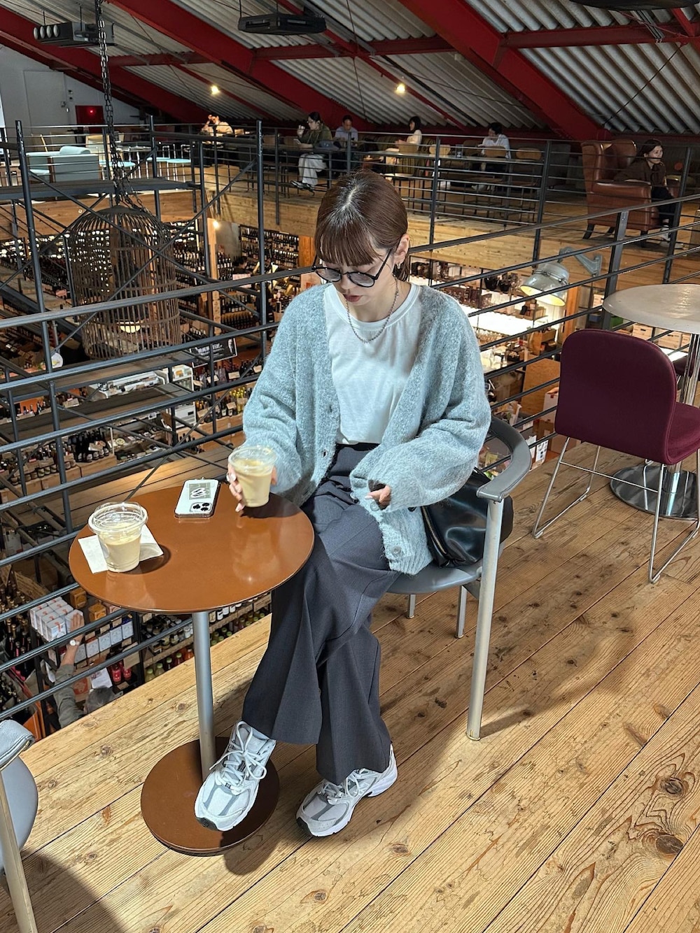 グレー系のカーディガン/ボレロ、グレー系のスラックス、ホワイト系のスニーカーを着用したレディースの秋コーディネートの1枚目の写真