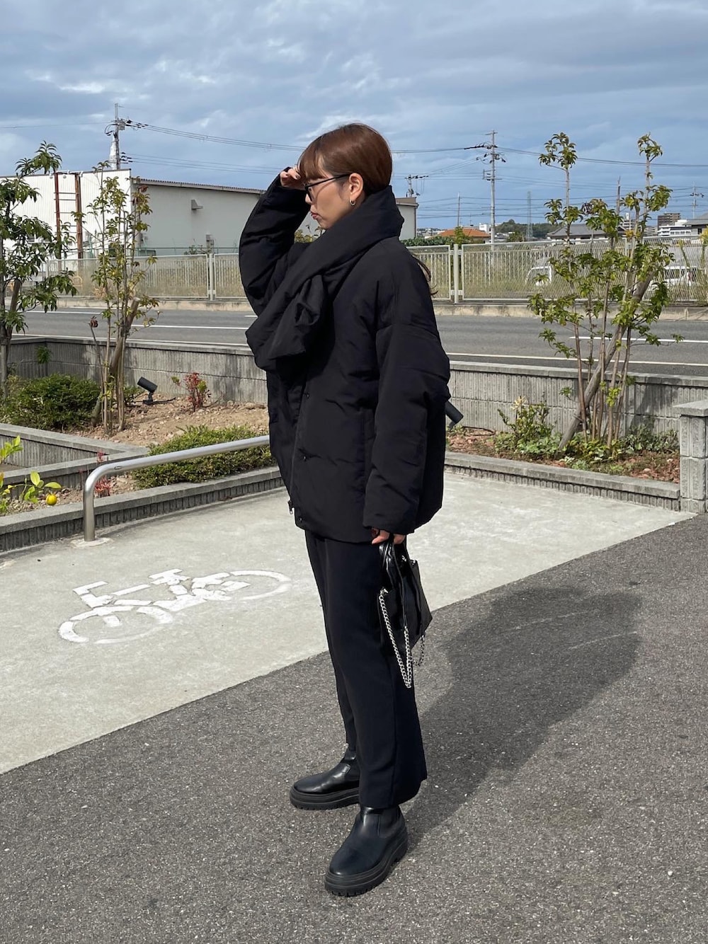 ブラック系のダウンジャケット/コート、ブラック系のスカート、ブラック系のショルダーバッグを着用したレディースの秋コーディネートの1枚目の写真