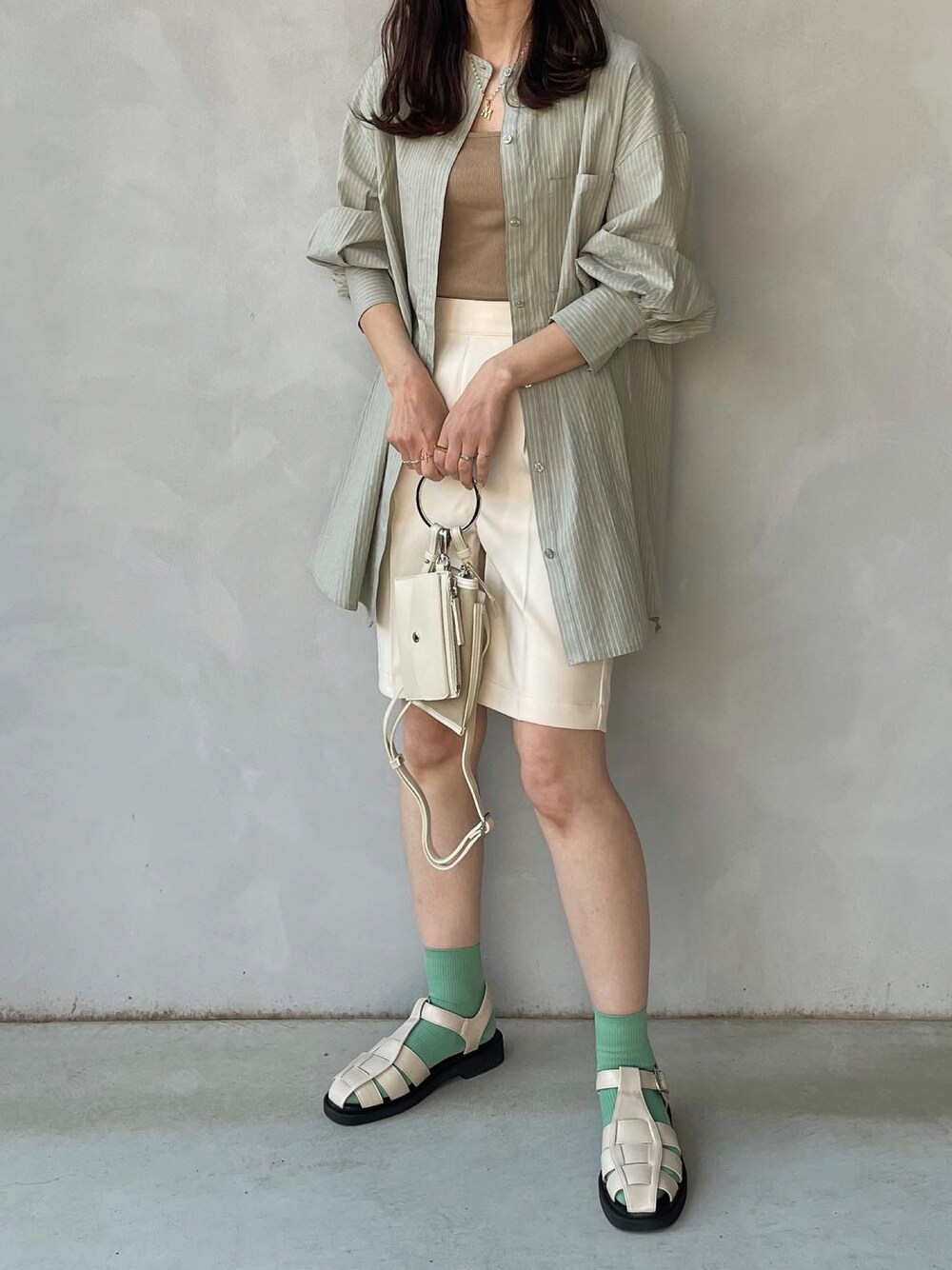グリーン系のシャツ/ブラウス、ホワイト系のその他パンツ、ベージュ系のショルダーバッグを着用したレディースの春コーディネートの1枚目の写真