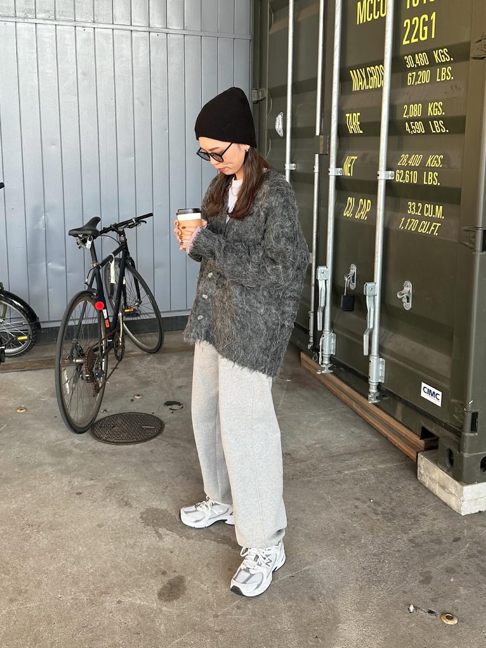 ブラック系のカーディガン/ボレロ、ホワイト系のスニーカー、ブラック系のニットキャップ/ビーニーを着用したレディースの秋コーディネートの1枚目の写真