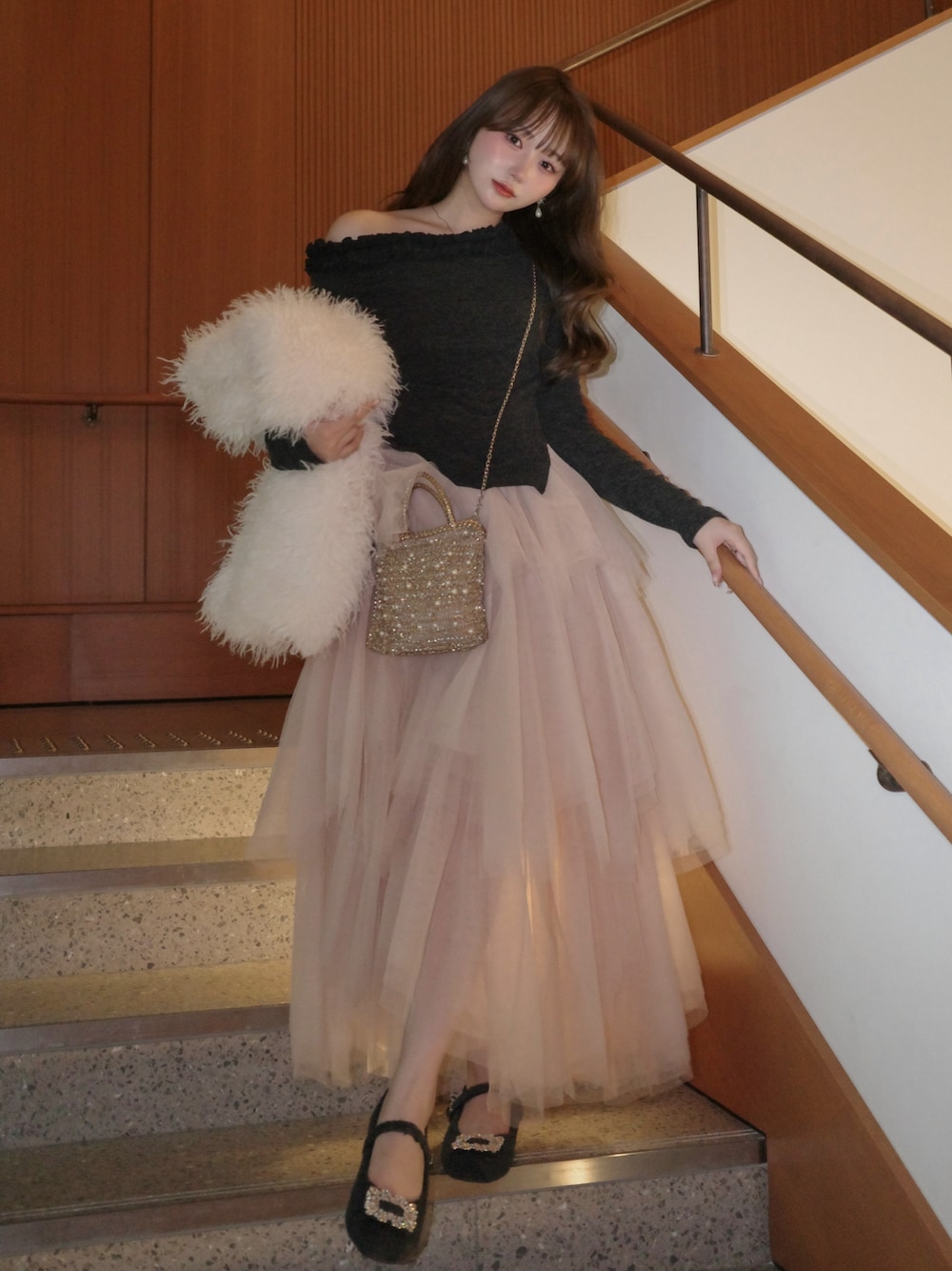 グレー系のシューズ、ピンク系のスカート、グレー系のセットアップを着用したレディースの冬コーディネートの1枚目の写真